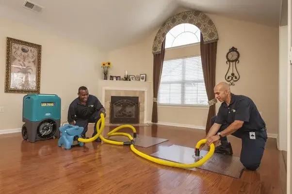 Crew drying an Oklahoma City living room with a dehumidifier