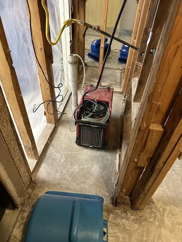 Water damage and drying equipment with exposed studs in an Oklahoma City basement