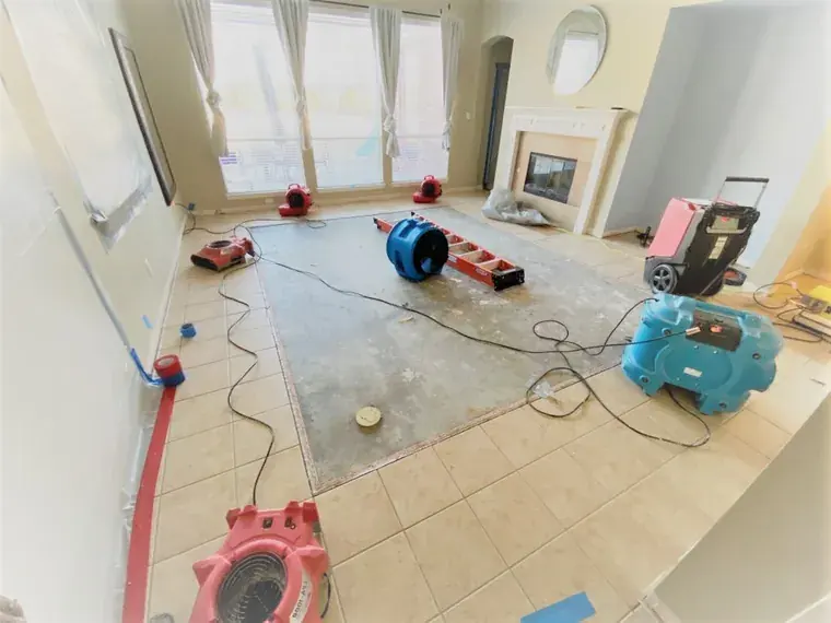Air movers and dehumidifiers drying a flooded living room in an Oklahoma City home.