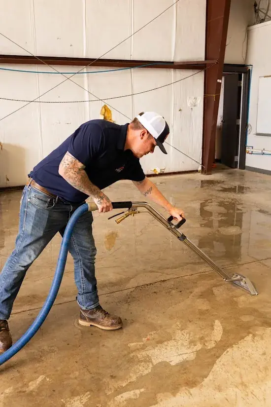 Technician extracting standing water from a floor in an Oklahoma City home